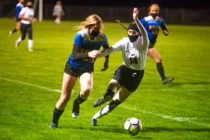 Adna junior forward Summer White battles an Ocosta defender at home on Wednesday.