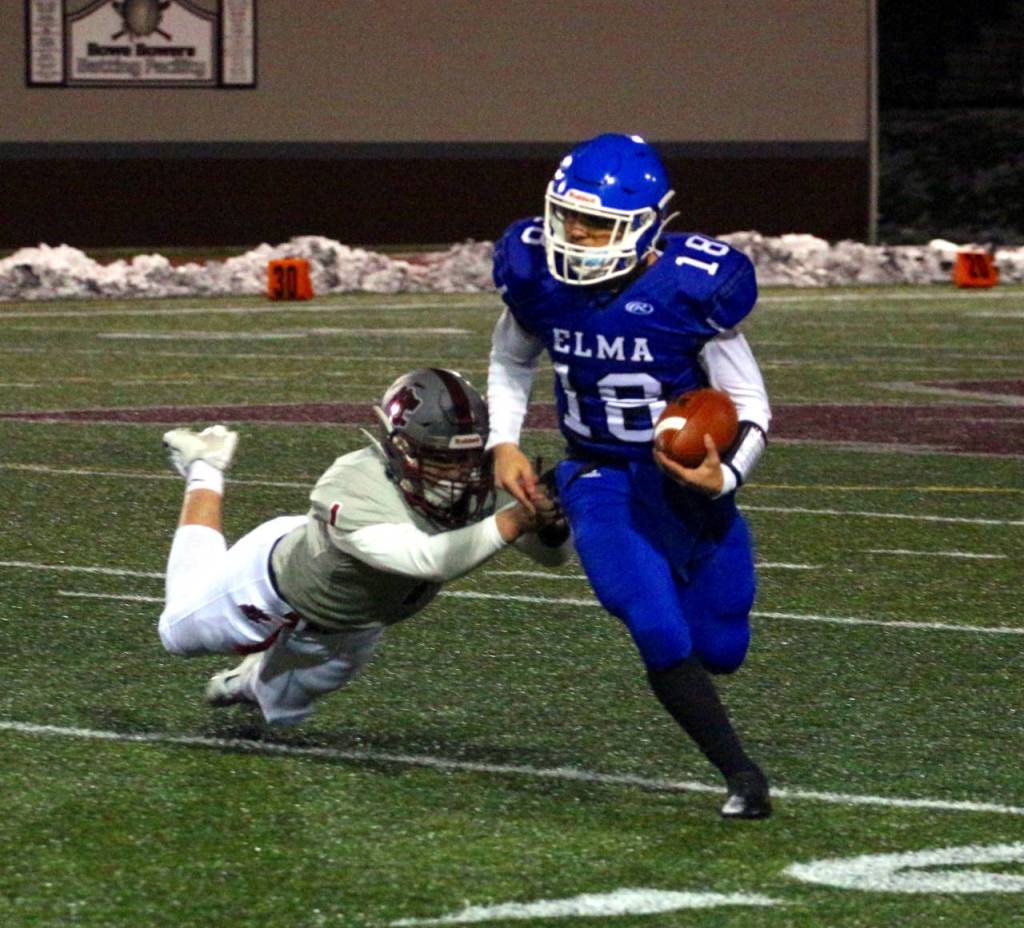 RYAN SPARKS | THE DAILY WORLD Elma quarterback René Duran (18) escapes the tackle of Hoquiam defender Kohltan Philamalee during the Eagles 27-13 victory on Monday at Jack Rottle Field in Montesano.