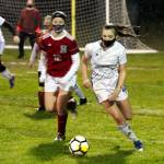 PHOTO BY BEN WINKELMAN Elmas Harlee Nelson (13) and Hoquiams Alyssa Perry (12) battle for possession during the Eagles 2-1 victory on Thursday at Olympic Stadium in Hoquiam. Perry scored the Grizzlies lone goal in the 46th minute.