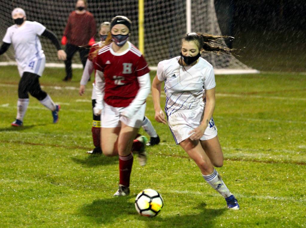 PHOTO BY BEN WINKELMAN Elmas Harlee Nelson (13) and Hoquiams Alyssa Perry (12) battle for possession during the Eagles 2-1 victory on Thursday at Olympic Stadium in Hoquiam. Perry scored the Grizzlies lone goal in the 46th minute.