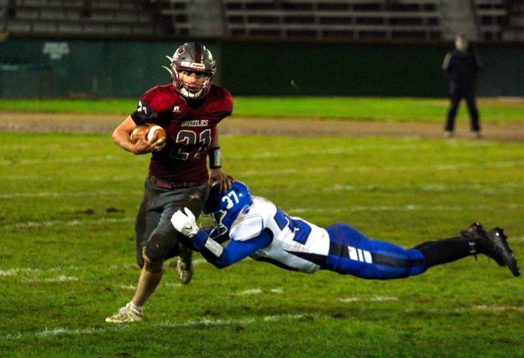 Hoquiam running back Troy McMinn, left, escapes the tackle of Elma linebacker Jarred Bailey on Friday at Olympic Stadium in Hoquiam. (Ryan Sparks | The Daily World)
