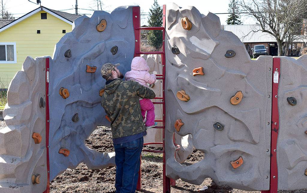 DAN HAMMOCK | THE DAILY WORLD 
The new playground equipment at Garley Park in south Aberdeen was getting a workout on a warm, sunny afternoon Thursday. Jessica Byers brought her 5-year-old son, Tyr, and 3-year-old daughter, Ava; they both took turns on the zip line, getting an assist from Josh White and Ashley Byers, both of Westport. Ava later took a whack at the adjacent climbing wall, with White providing a boost.