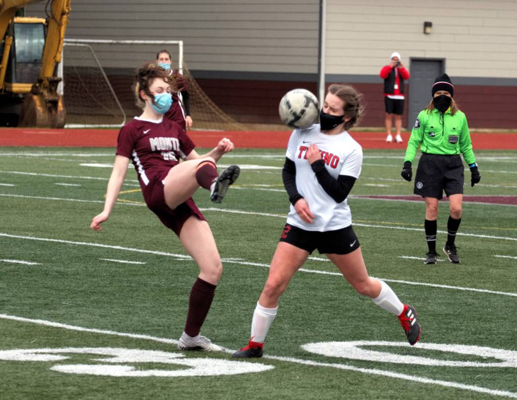 Montesano senior midfielder Brooke Streeter, left, sends the ball forward while Teninos Grace Vestal defends during the 1A District 4 title game on Saturday, March 20, 2021 in Montesano. (Ryan Sparks | The Daily World)