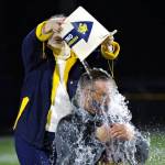 PHOTO BY BEN WINKELMAN Hoquiam School District Superintendent Mike Villarreal (sitting) makes good on a friendly wager with Aberdeen SD Superintendent Dr. Alicia Henderson after Aberdeens 30-8 win on Saturday at Stewart Field in Aberdeen.