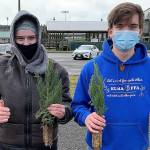 TYLER RENZ / ELMA FFA ADVISOR 
Elma FFA members Taylor Kershaw, left, and Sam Gillis hold two of the 1,700 giant sequoia and California redwood trees given away to 111 people at the Elma Fairgrounds March 20 and 21.