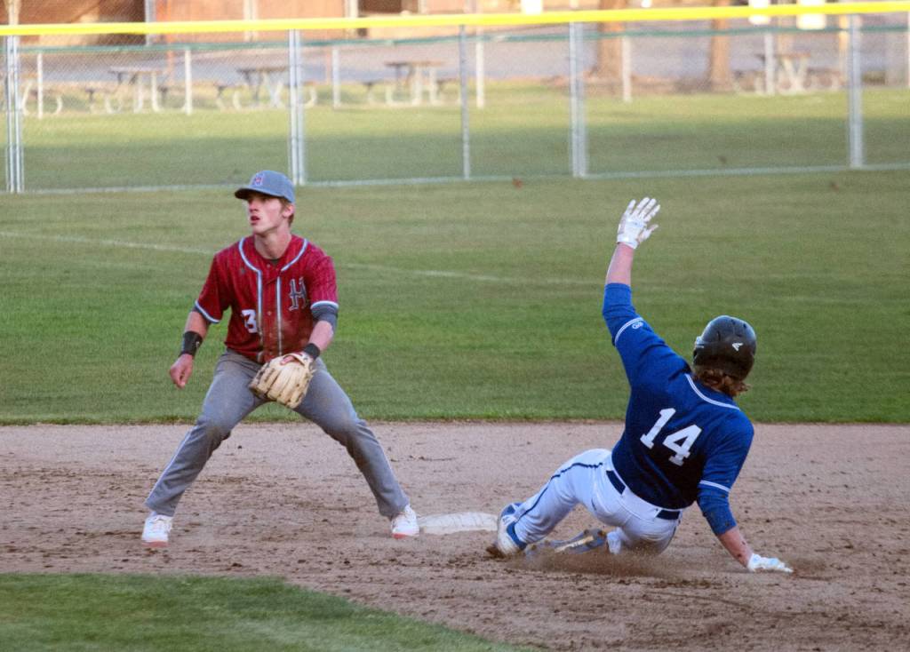 Elmas Jarred Bailey (14) steals second base as Hoquiam infielder Cody Drake awaits a throw during a double header on Tuesday in Hoquiam. (Ryan Sparks | The Daily World)