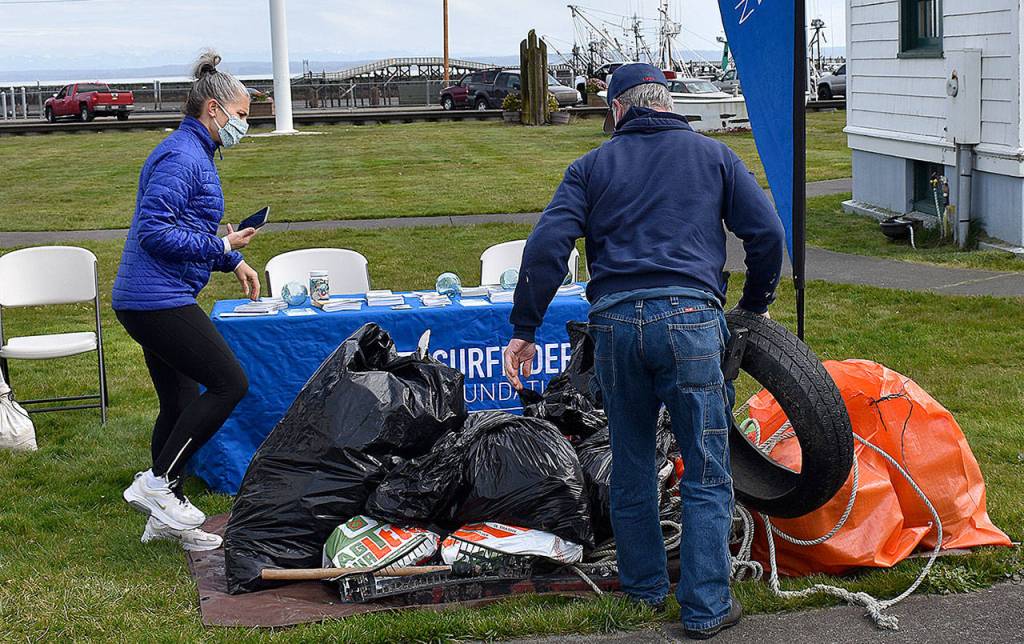 DAN HAMMOCK | THE DAILY WORLD 
Jill Williams, left, Vice Chair of the Olympia Surfriders, checks in trash collected at the south beaches Saturday at the Westport Maritime Museum.