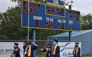 DAN HAMMOCK | THE DAILY WORLD
Aberdeen High School seniors walk to their seats under the scoreboard at Stewart Field on Friday evening.