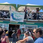 DAN HAMMOCK | THE DAILY WORLD 
Paulas Porch Pirates perch atop Sea Birds Gifts and Candy in Westport and toss taffy, beads and doubloons to passersby on Westhaven Drive in Westport on Saturday, part of Rusty Scuppers Pirate Daze.