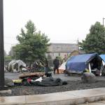 DAVE HAVILAND | THE DAILY WORLD 
Remaining Aberdeen TASL residents gather their belongings as the fence surround the city-run homeless camp is taken down Friday morning. The city closed the camp Friday at noon.