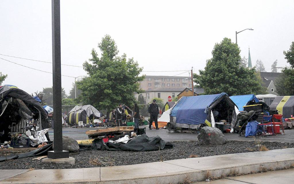 DAVE HAVILAND | THE DAILY WORLD 
Remaining Aberdeen TASL residents gather their belongings as the fence surround the city-run homeless camp is taken down Friday morning. The city closed the camp Friday at noon.