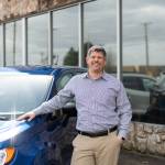 Photo By Alicia Tisdale 
Damon Gleason stands in front of the Five Star Ford Dodge-Chrysler-Jeep dealership.