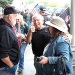 RYAN SPARKS | THE DAILY WORLD Star Wars Shop owner/operator Don Sucher, middle, gives a thumb up while speaking with supporters outside his shop on Saturday in Aberdeen.