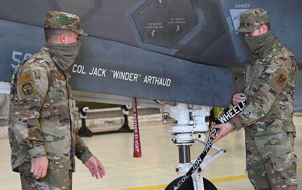 U.S. Air Force photo by Senior Airman Heather LeVeille 
From left, U.S. Air Force Senior Airman Joshua Owens and Staff Sgt. Hunter Davis, 33rd Aircraft Maintenance Squadron crew chiefs, reveals the name of Col. Jack Arthaud, 33rd Fighter Wing commander, on aircraft 50-33 during a change of command ceremony at Eglin Air Force Base, Fla., on July 30, 2021. Davis and Owens have been charged with the care and maintenance of aircraft 50-33.