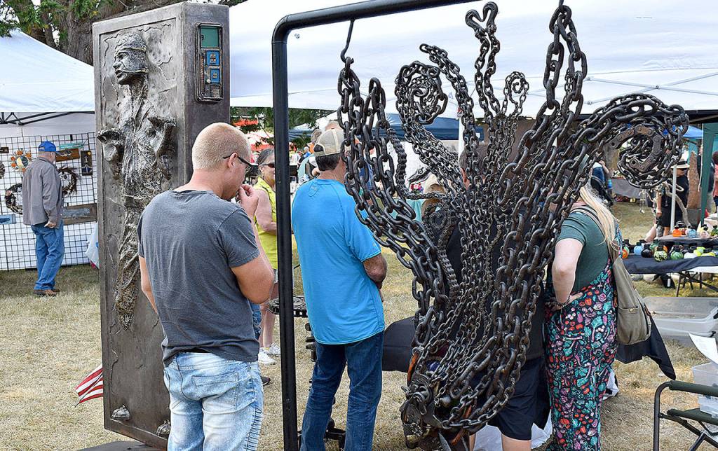 DAN HAMMOCK | THE DAILY WORLD 
Tokeland metal artist Yoseph Adams booth drew a crowd, as usual, at Saturdays Tokeland Woodfest.