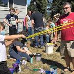 Photo by Kathryn Smith 
Tony Enzler looks on as his son, Winston, prepares to launch a paint-filled balloon at the Cosi Art Center on Saturday, Aug. 28, 2021.
