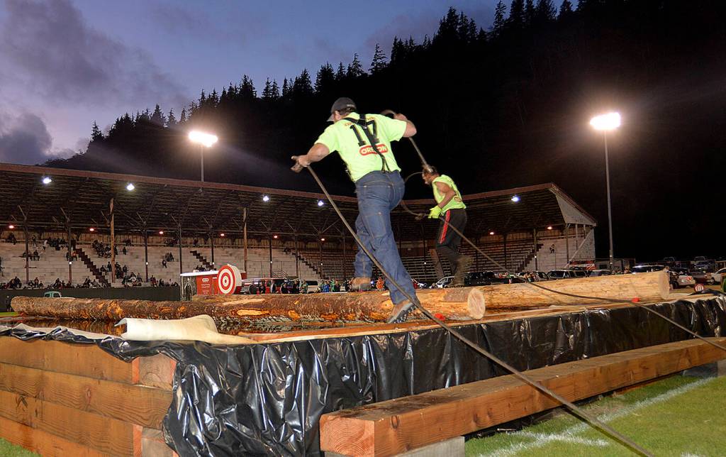 DAN HAMMOCK | THE DAILY WORLD 
Two competitors drag chokers and try to stay dry crossing the pond during the 2019 Hoquiam Loggers Playday competition.