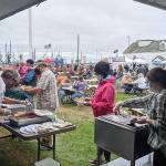 Volunteer grillers prepare oysters, salmon, white fish and sides at the Westport Seafood Festival Saturday. The barbecue grills were hot and hundreds went through the food line and vendor tents set up in front of the Westport Maritime Museum from noon to 5 p.m. (Courtesy Westport Grayland Chamber of Commerce)