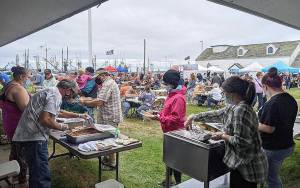 Volunteer grillers prepare oysters, salmon, white fish and sides at the Westport Seafood Festival Saturday. The barbecue grills were hot and hundreds went through the food line and vendor tents set up in front of the Westport Maritime Museum from noon to 5 p.m. (Courtesy Westport Grayland Chamber of Commerce)