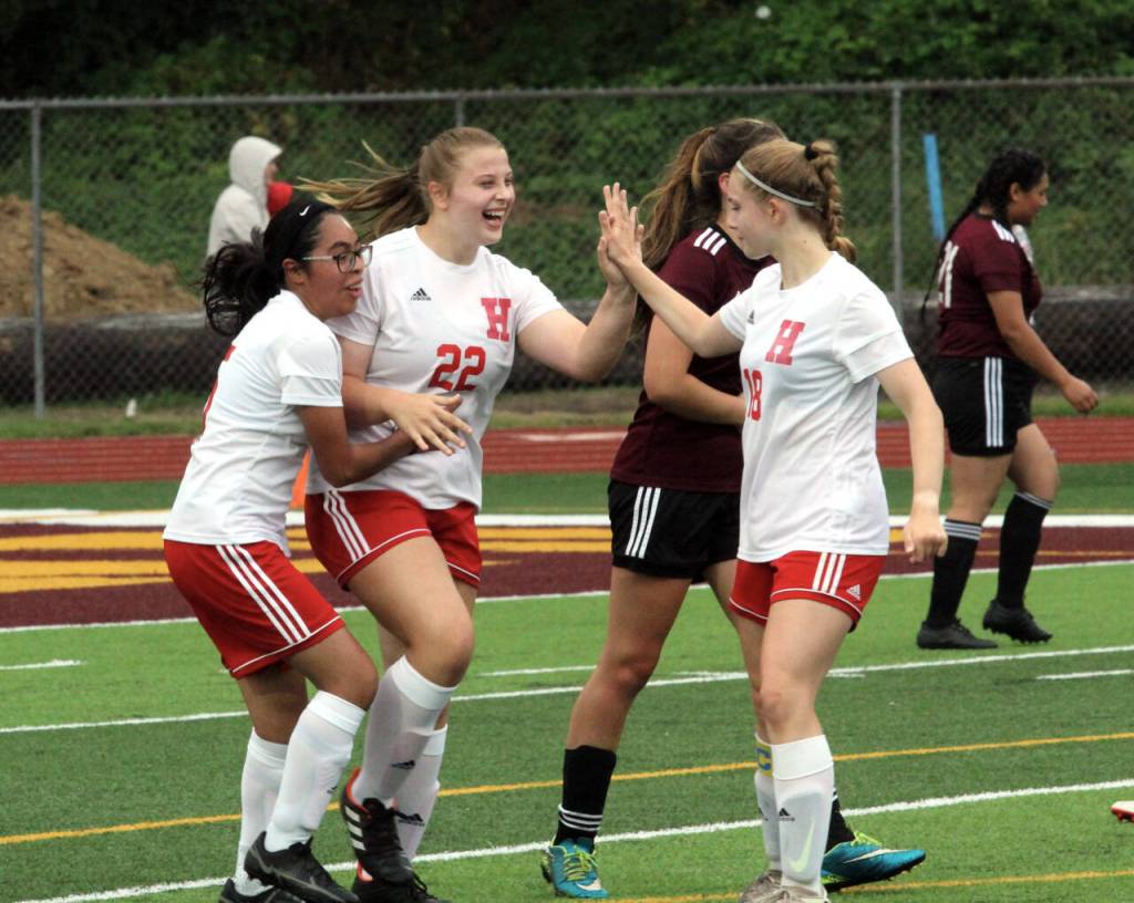 PHOTO BY BEN WINKELMAN Hoquiam forward Maci Winkelman (22) is congratulated by sister Ellie Winkelman (18) and teammate Briana Herrera after scoring a goal in the Grizzlies 4-1 win over Raymond-South Bend on Thursday in South Bend.