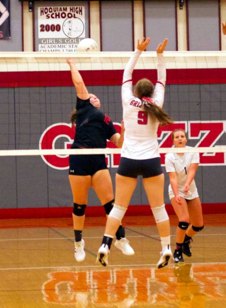 PHOTO BY PATTI REYNVAAN Raymonds Sidney Swogger, left, records one of her team-high 10 kills while being defended by Hoquiams Faith Prosch (9) on Thursday in Hoquiam. The Seagulls won in straight sets.