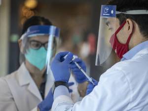 Matt Talavera, a pharmacist for CVS, fills a syringe with COVID-19 vaccine outside the Life Care Center in Kirkland, where some employees were vaccinated on Dec. 28, 2020. Steve Ringman | The Seattle Times