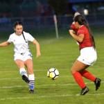 RYAN SPARKS | THE DAILY WORLD Elma forward Chloe Clark, left, sends a cross past Hoquiam defender Ruby Wells during a game on Thursday in Hoquiam. Clark scored two goals in the contest.