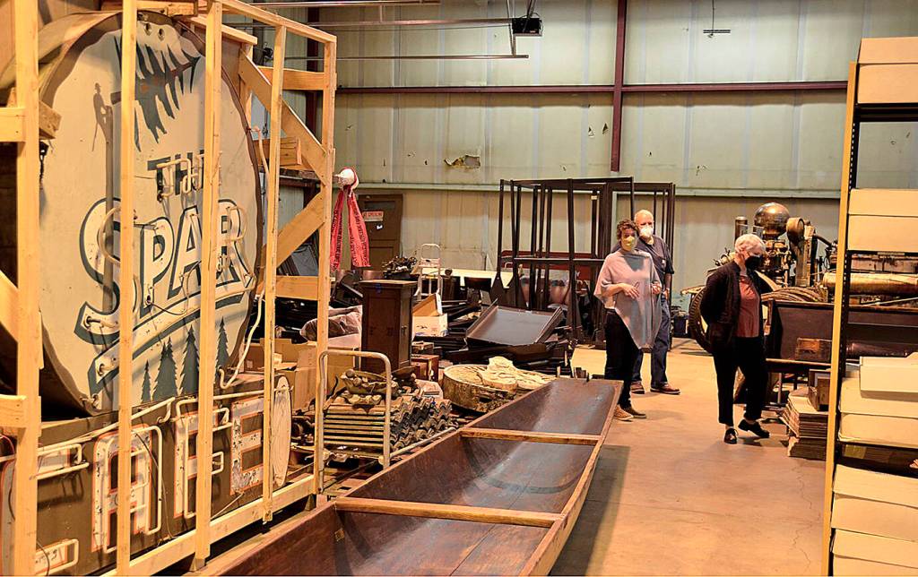 Courtesy of Aberdeen museum board
Aberdeen museum board member George Donovan and two people from the Washington State Historical Society tour the collection in its current location, a warehouse in the Port district. At the left is the last neon sign that hung outside the Spar Cafe, discovered in the armory building annex after the armory fire.