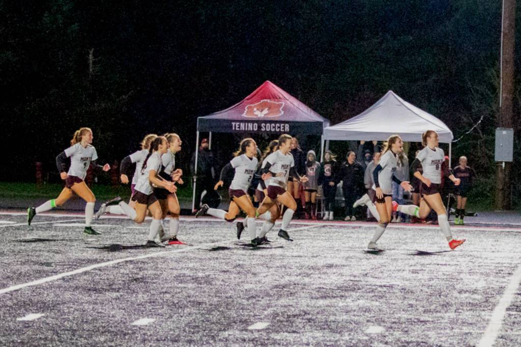 PHOTO BY SHAWN DONNELLY Montesano players storm the field after Jaiden King converted the fourth and decisive goal in a penalty-kick shootout to defeat Tenino 1-0 (4-2 on PKs) in a WIAA 1A State Girls Soccer Tournament quarterfinal match on Saturday in Tenino.