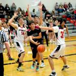 RYAN SPARKS | THE DAILY WORLD Ocostas Mark Lewis passes while being defended by Raymonds Talan Yearout (34), Tre Seydel and Morgan Anderson (30) during the Seagulls 87-53 victory on Wednesday at Raymond High School.