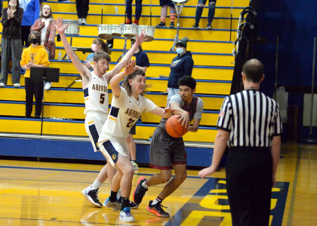 RYAN SPARKS | THE DAILY WORLD Hoquiams Gio Foster, right, looks to pass while being defended by Aberdeens Ashdon Swope (21) and Andrew Troeh (5) during Hoquiams 60-46 win in Aberdeen on Thursday.