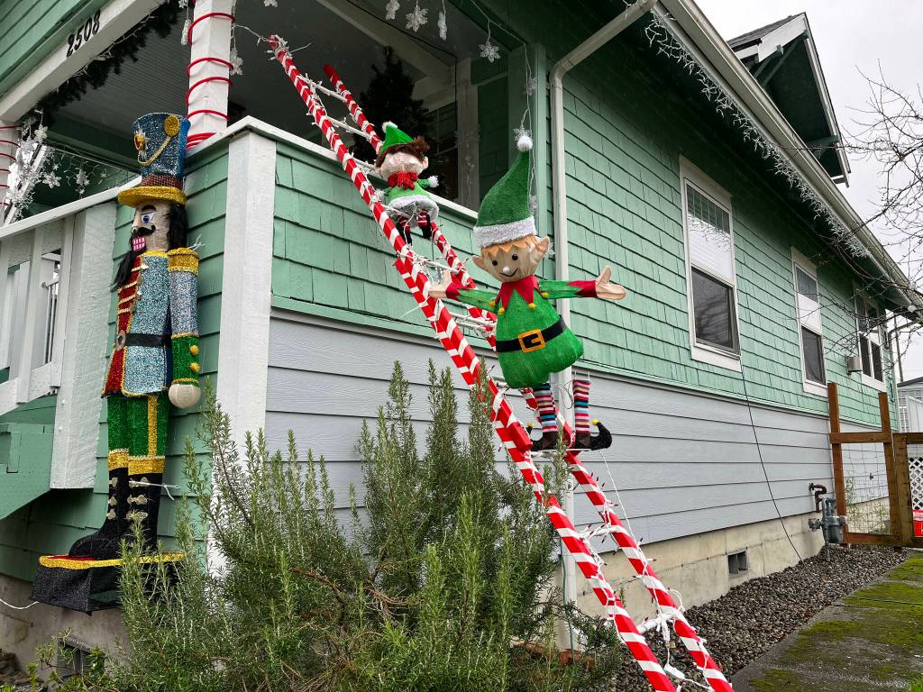 Christmas elves "climb" the ladder Michele Crane built for her "Christmas Wonderland" display, which decks Crane's front yard that sits in the 2500 block of Queets Avenue, in Hoquiam.