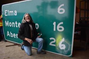 Matthew N. Wells | The Daily World
Wil Russoul, executive director of the Downtown Aberdeen Association, could hardly wait to receive the mileage sign that was posted on Highway 8 approximately 6 miles from Elma, 16 miles to Montesano and 26 miles from Aberdeen, because its a piece of music history. The sign will at some point help greet travelers as they enter downtown Aberdeen.