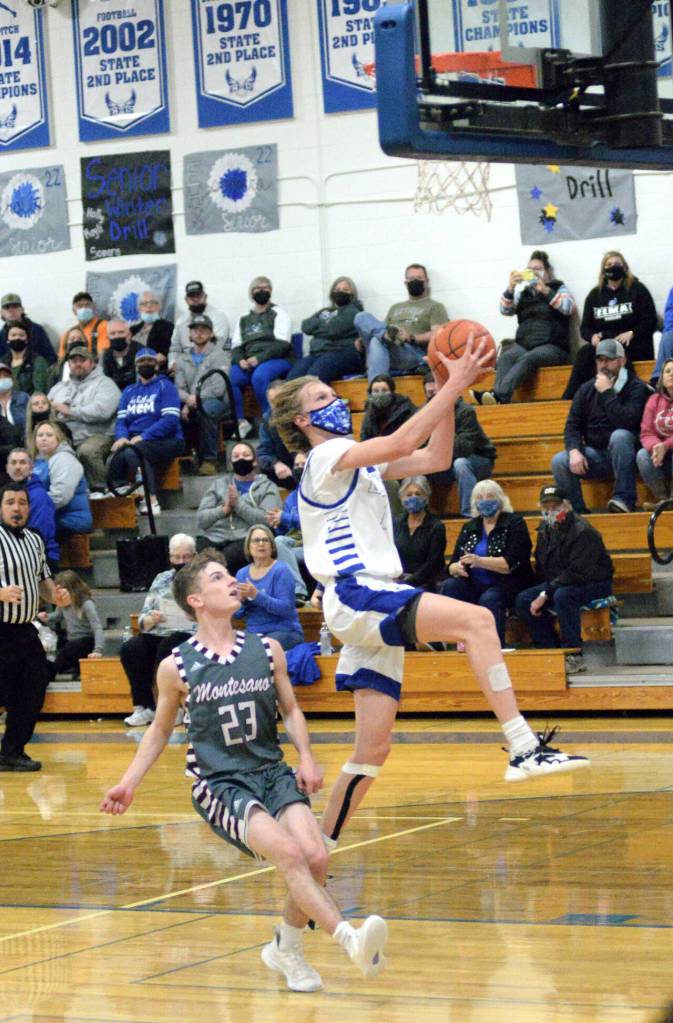 RYAN SPARKS | THE DAILY WORLD Elmas Canon Seaberg, right, scores on a layup in front of Montesanos Trent Adams during Montesanos 57-51 win over Elma on Tuesday in Elma.