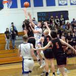RYAN SPARKS | THE DAILY WORLD Elma senior Jerred Bailey, middle, shoots against Teninos Jack Burkhardt (11) during the Eagles 50-47 loss on Tuesday in Elma.