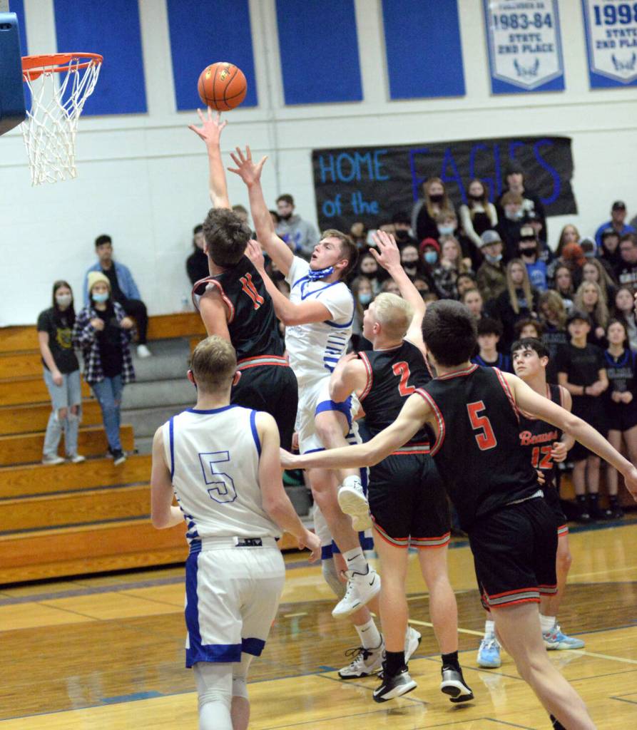 RYAN SPARKS | THE DAILY WORLD Elma senior Jerred Bailey, middle, shoots against Teninos Jack Burkhardt (11) during the Eagles 50-47 loss on Tuesday in Elma.