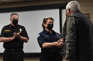 Matthew N. Wells | The Daily World 
Aberdeen Fire Service Specialist Monica Myers, center, receives an award and shakes hands with Mike Michener, community volunteer lead from American Red Cross South Puget Sound and Olympics Chapter, as Aberdeen Fire Chief Tom Hubbard applauds the moment on Friday, Feb. 11, 2022.