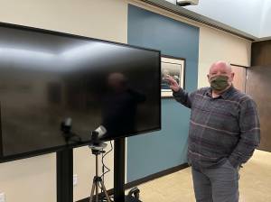 Aberdeen Mayor Pete Schave shows off the new 70-inch television screen that will help council members see members of the public who tune in, via Zoom, to council meetings when their meetings change from a remote setting to a hybrid setting. Currently, Schave said the plan is to switch from remote to hybrid at the Wednesday, March 9, 2022 meeting. (Matthew N. Wells | The Daily World)