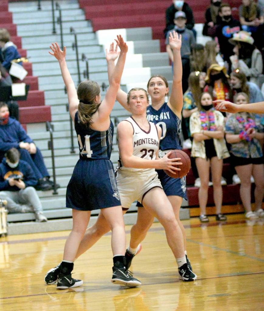RYAN SPARKS | THE DAILY WORLD Montesano senior Paige Lisherness (23) powers through Kings Way Christian defenders Laurel Quinn (14) and Riley Philbrook to score two of her game high 24 points in the Bulldogs 53-39 victory in the 1A District 4 semifinals on Tuesday in Montesano.