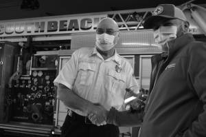 Matthew N. Wells | The Daily World
Dennis Benn, fire chief at South Beach Regional Fire Authority, left, shakes hands with Dan Wirth, executive director of American Red Cross South Puget Sound and Olympics Chapter, after Wirth helped present Benn and his crew an award for saving the life of a family in Grayland through a joint campaign to ensure homes have working smoke alarms.