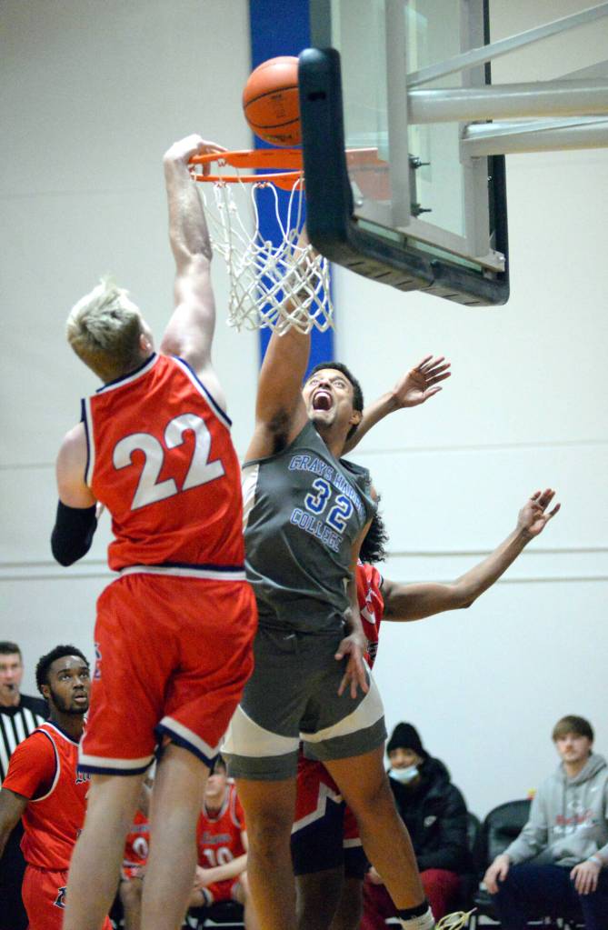RYAN SPARKS | THE DAILY WORLD Grays Harbor College freshman David Featherston Jr. (32) attacks the rim while defended by Lower Columbia forward Ashton Harvey (22) during the Chokers 67-63 win on Wednesday in Aberdeen.