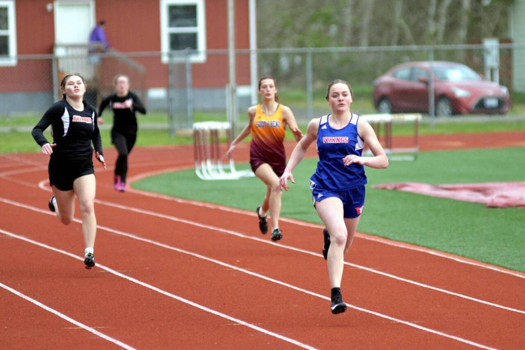 RYAN SPARKS | THE DAILY WORLD Willapa Valleys Emily Wilson, right, leads the field down the stretch of the girls 200 meters at the Henrie-Weisel Tri-District Meet on Thursday in South Bend.