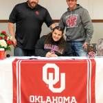PHOTO BY PAMELA PELAN Hoquiam track and field athlete Tyara Straka, sitting, is flanked by her father, Shaun, left, and Hoquiam head coach Tim Pelan during a signing ceremony on Saturday.