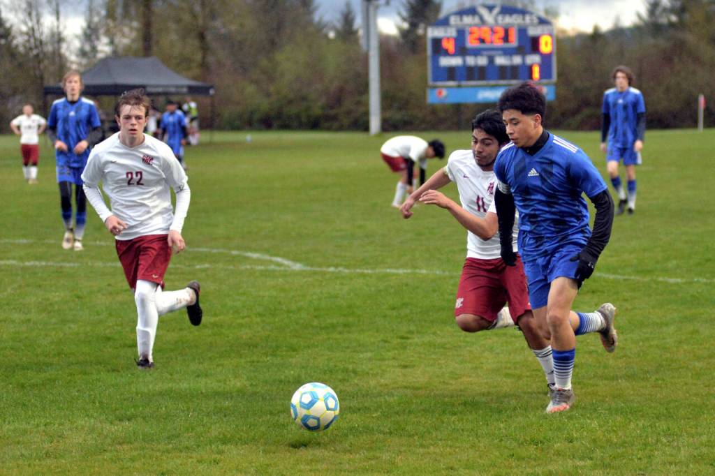 RYAN SPARKS | THE DAILY WORLD Elma senior Manny Hernandez, right, is pursued by Hoquiam defenders Daniel Cortes Verdejo (11) and Mason Kelly (22) during Elmas 9-0 win on Wednesday in Elma. Hernandez scored a goal and added two assists in the victory.