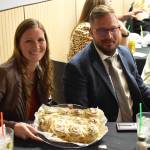 Kassey Robbins (left) holds a plate of cinnamon rolls she won for $200 in a dessert auction for the 2022 Elma Citizen of the Year event at the Elma Eagles Banquet Hall on April 29, 2022.
