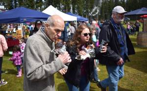 Allen Leister | The Daily World 
Two fairgoers enjoy barbequed turkey legs while exploring the Old Timers Fair on Saturday, May 7, 2022, at Mary M. Knight School District grounds in Elma.