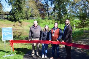 Photo Courtesy of Nichole Pas 
Summit Pacific Medical Foundation President Brian Smith (holding scissors) stands alongside foundation board members and Summit Pacific CEO Josh Martin (right) to celebrate the grand opening of the newest addition of the trail expansion at the hospital campus on May 20, 2022, in Elma.