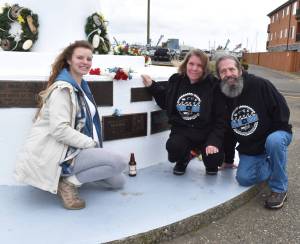 Bryan Scott Moores family  his sister Caitlin, and his parents Audrey and John Moore  lay a single blue flower and a Lagunitas Brewings A Little Sumpin Sumpin Ale at his memorial on Sunday, May 29, 2022, after The Blessing of the Fleet at Fishermans Memorial in Westport. Cold beer was pretty much his favorite, Bryans father said. (Matthew N. Wells | The Daily World)