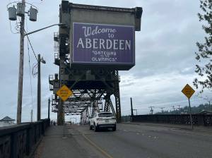 Matthew N. Wells | The Daily World
On Thursday morning, July 7, 2022, a motorist heads west over the Wishkah Street Bridge. The slogan on the purple sign Gateway to the Olympics, is just what John Shaw, and many in the Grays Harbor County community are trying to unlock in Aberdeen. The proposed key is the Gateway Center, which would serve as an information center about the community and provide help to businesses interested in moving to Aberdeen, among other things.