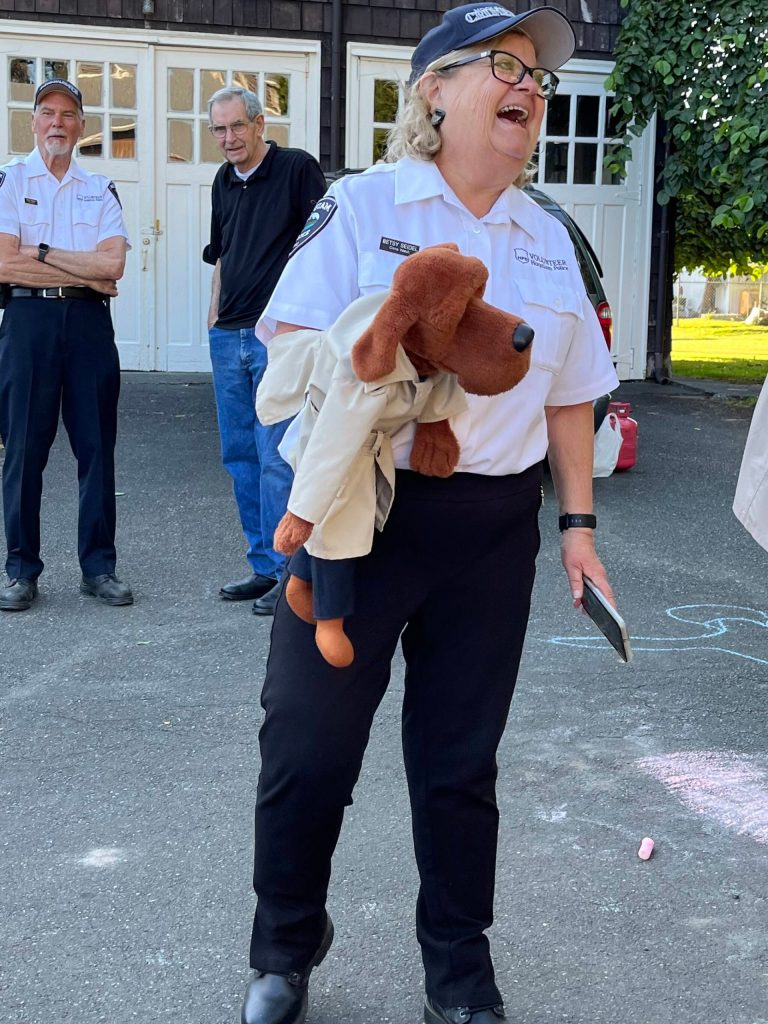 Matthew N. Wells | The Daily World 
Hoquiam Police Crime Watch Coordinator Betsy Seidel, with McGruff the Crime Dog Jr., entertained children and adults alike with an irrefutable, joyous glow during National Night Out on Tuesday, Aug 2, 2022, at Polson Museum. Behind Seidel are Hoquiam Police DepartmentCrime Watch officer Bob Martin, left, and U.S. Marine Corps veteran Jess Nations.
